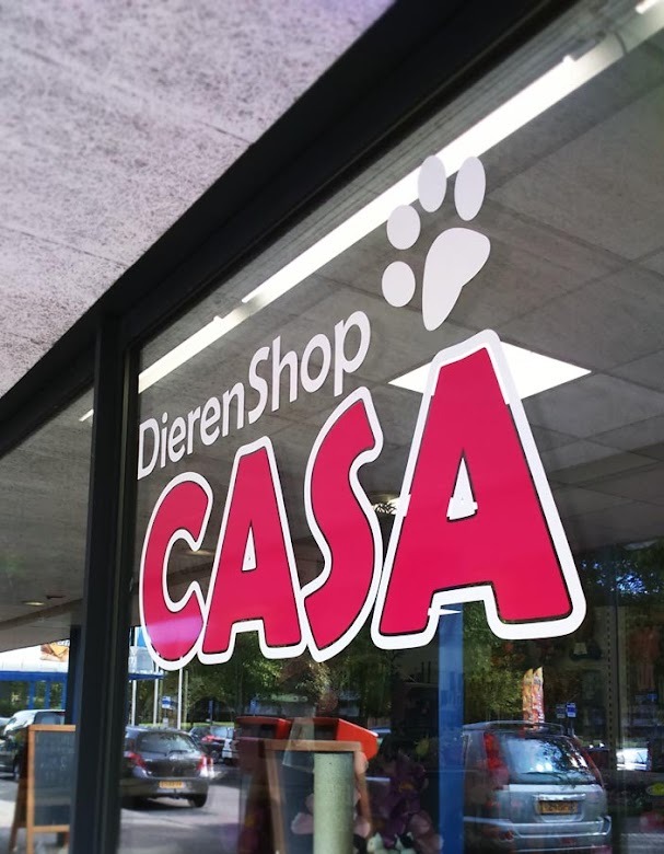 Het logo van Dierenshop Casa op het winkelraam aan de Zuiderhout in Oosterhout, rood-roze letters met een witte pootafdruk